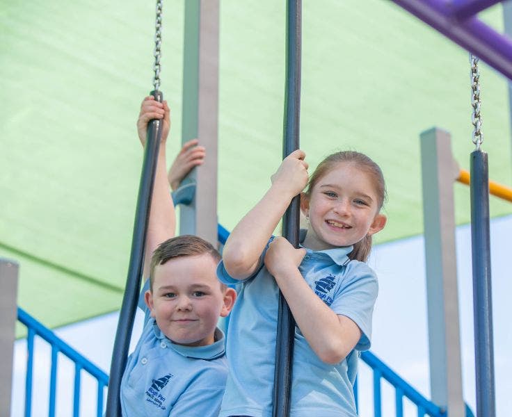 2 students on the fixed playground equipment