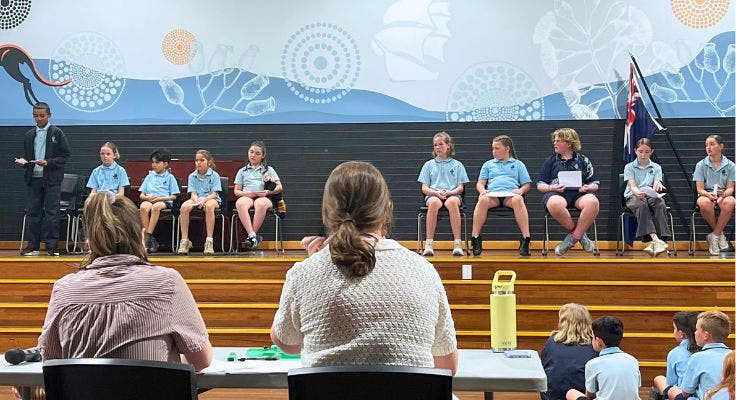Students sitting on stage waiting to do their Leadership voting speeches