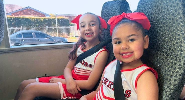 2 of our junior dancers in costume, on the bus, going to an event